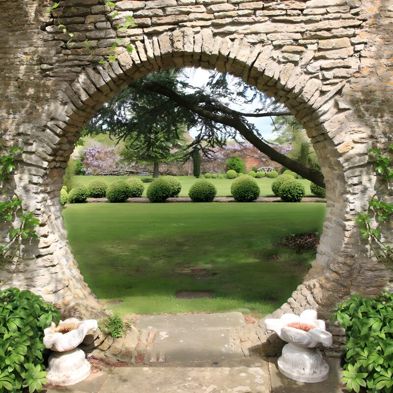 Enchanted Garden View Through Arched Stone