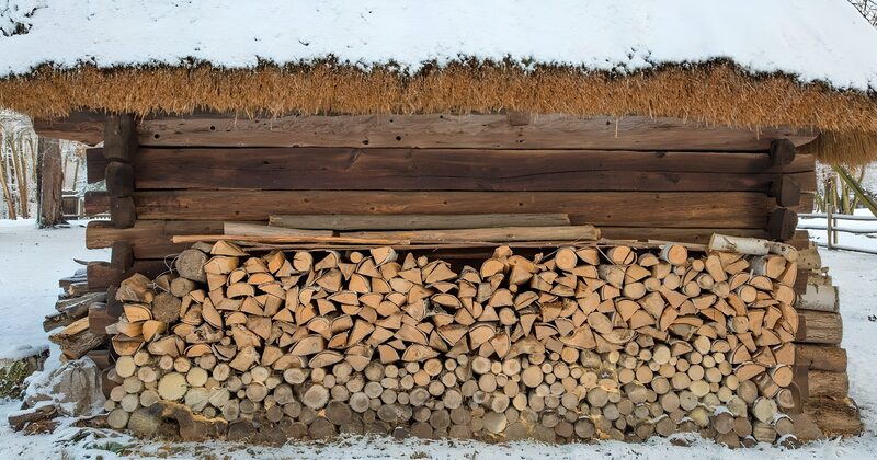 Rustic Woodpile by a Thatched Shed
